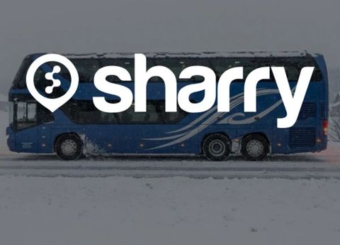 logo i nazwa firmy Sharry na tle niebieskiego autobusu, widok autobusu z boku i zaśnieżonej trasy